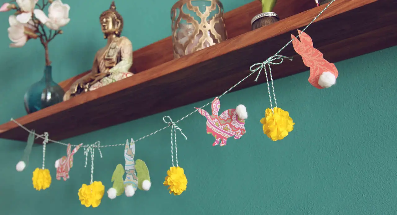Colourful DIY Easter garland with bunnies and pompom flowers to hang