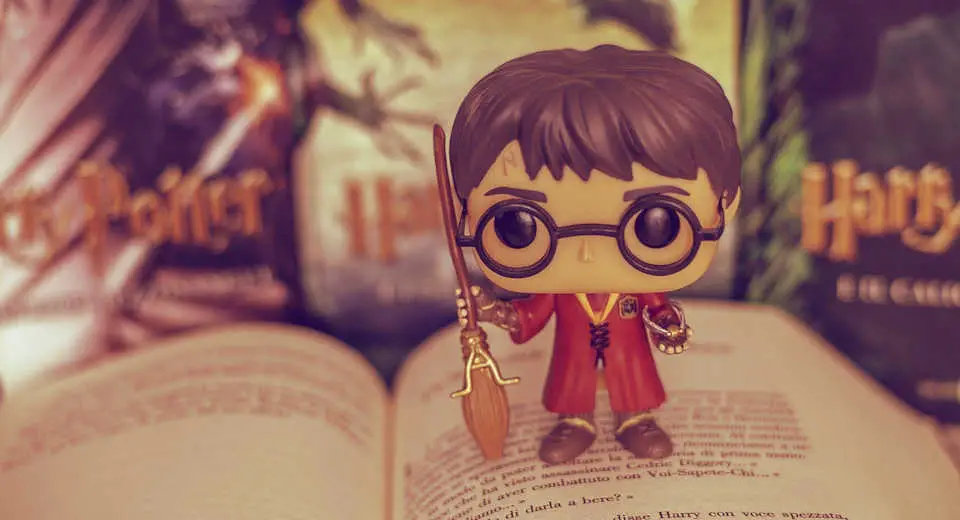 Eine Harry Potter Figur mit einem Besen steht auf einem der Romane, als wäre sie bereit jederzeit loszufliegen und ein trimgaisches Turnier auszufechten.