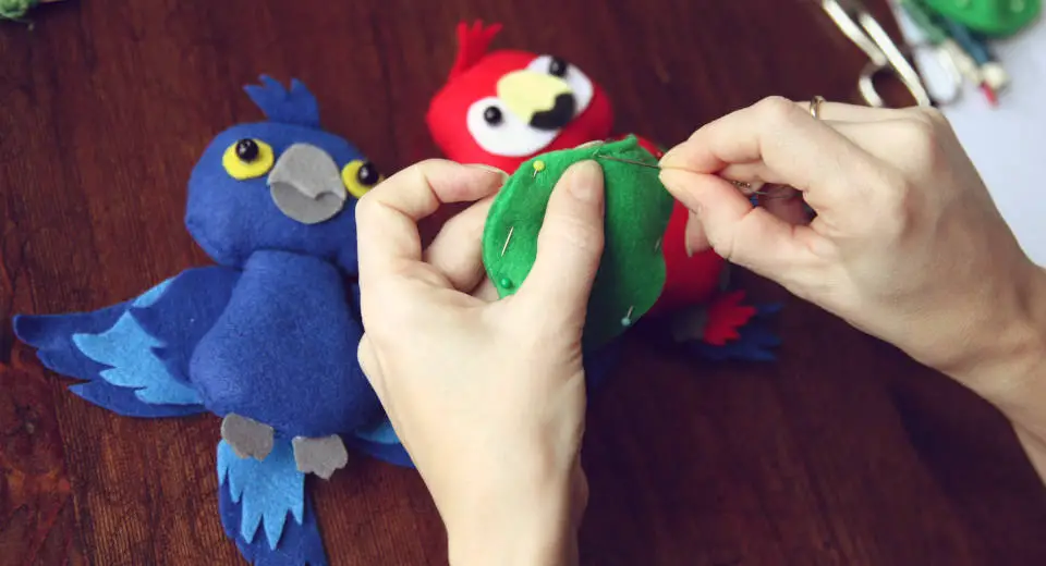 For the DIY felt Baby Mobile, sew five different parrots out of felt