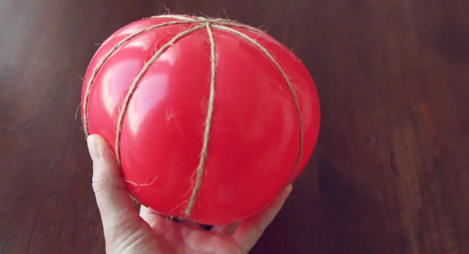 Pappmache-Kürbis basteln aus einem Luftballon, der mit Bindfaden umwickelt wird