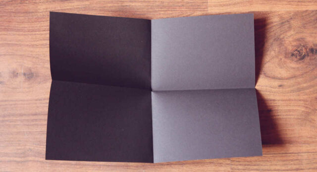 "Crafting a UFO card: Fold black construction paper."