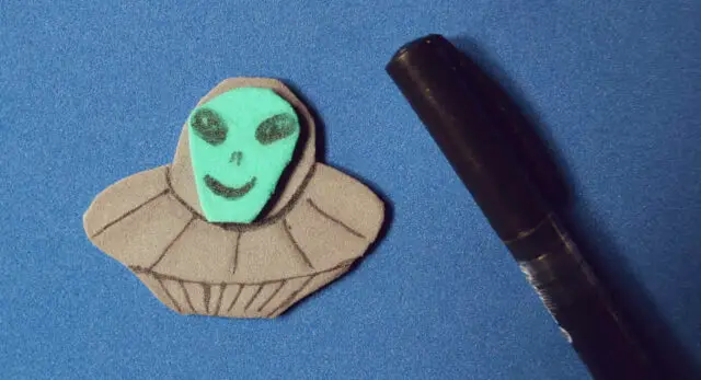 "Crafting a UFO card: Cut out UFO and alien head from foam rubber"