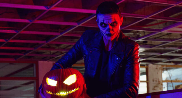 "Rocker zombie with Halloween pumpkin, a guest at a zombie theme party"